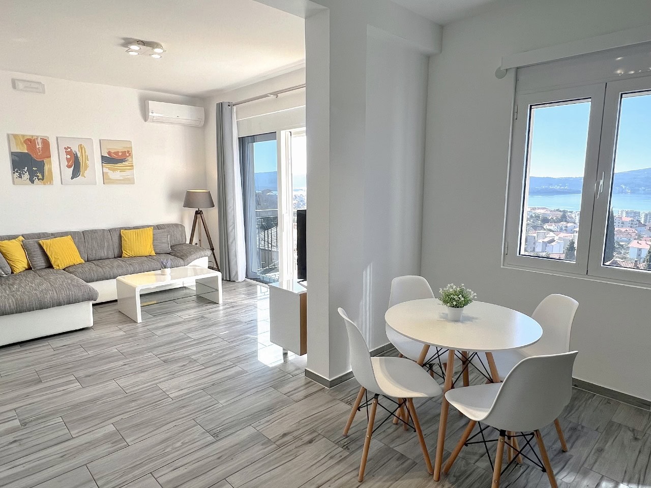 Helles Wohnzimmer mit Essbereich in einer Wohnung in Tivat, Montenegro, mit Panoramablick auf das Meer und moderner Einrichtung.