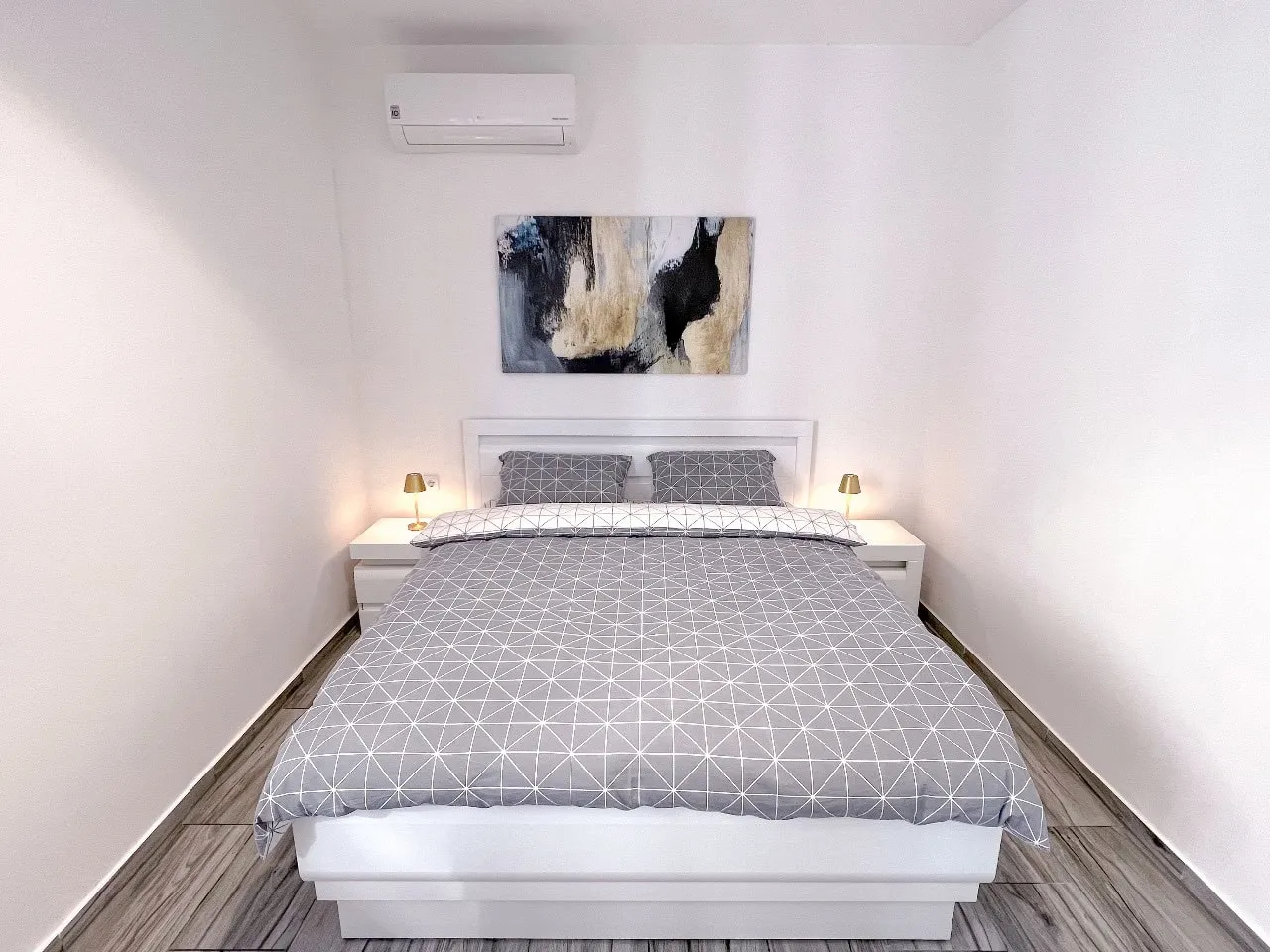 Modernes Schlafzimmer mit Doppelbett in einer Wohnung in Tivat, Montenegro: helles Interieur, Klimaanlage und Dekor.