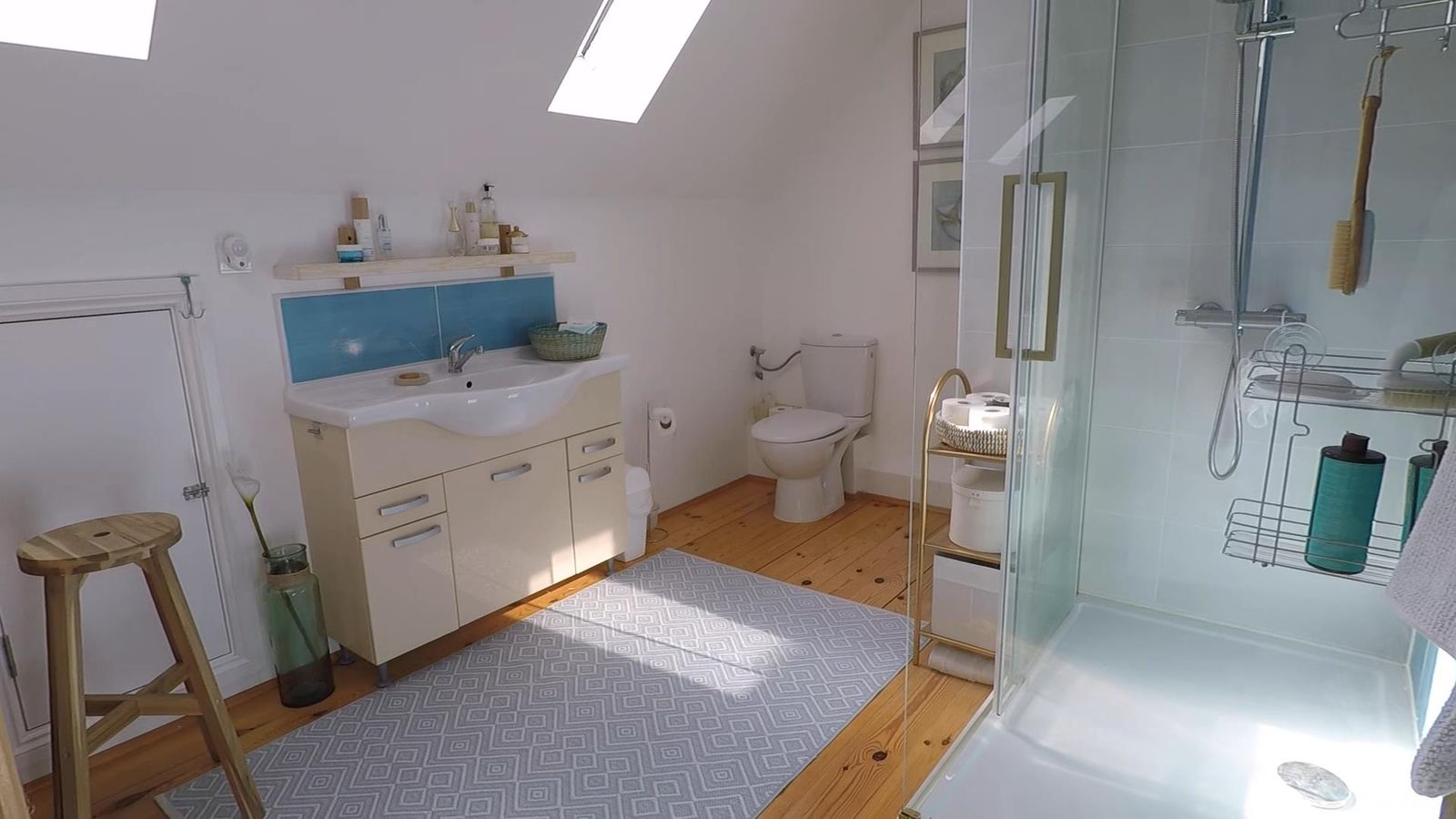 Karadağ, Kırımovice’deki evde aydınlık banyo: duş kabini, lavabolu dolap ve çatı penceresi.