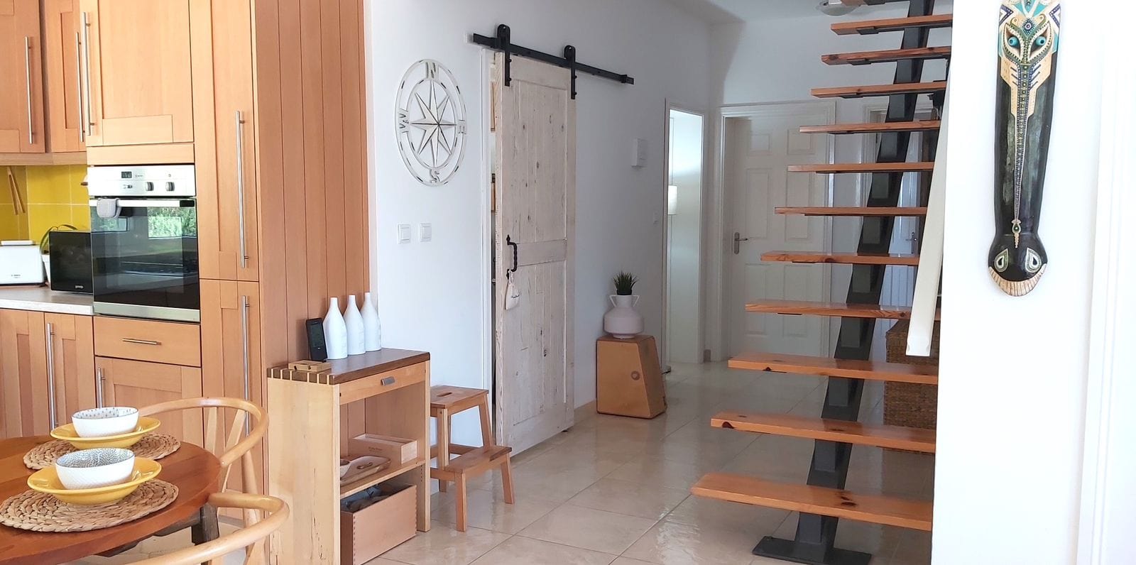 Ahşap mobilyalı ve merdivenli mutfak, Krymovitsa, Karadağ. Ahır kapılı ve dekorlu iç mekan.