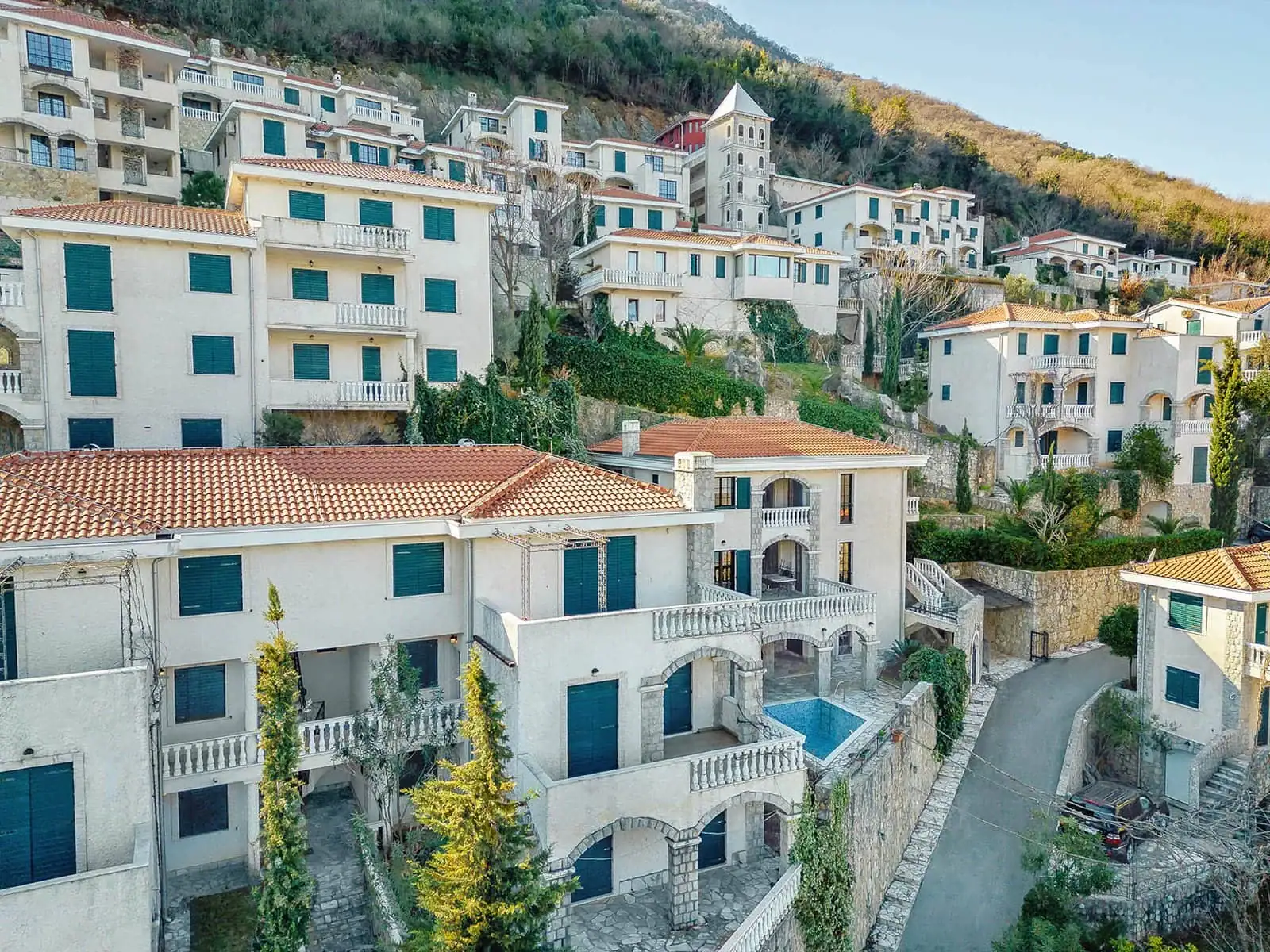 Residential complex with a pool and terraces in Kostanica, Montenegro: view of Mediterranean villas in the mountains.