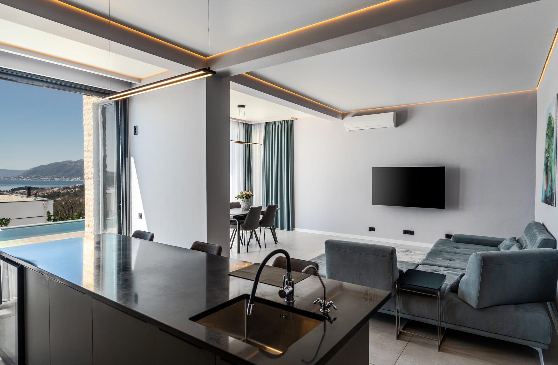 Modern living room with kitchen in a villa in Kavac, Montenegro: panoramic sea view, pool, and stylish interior.