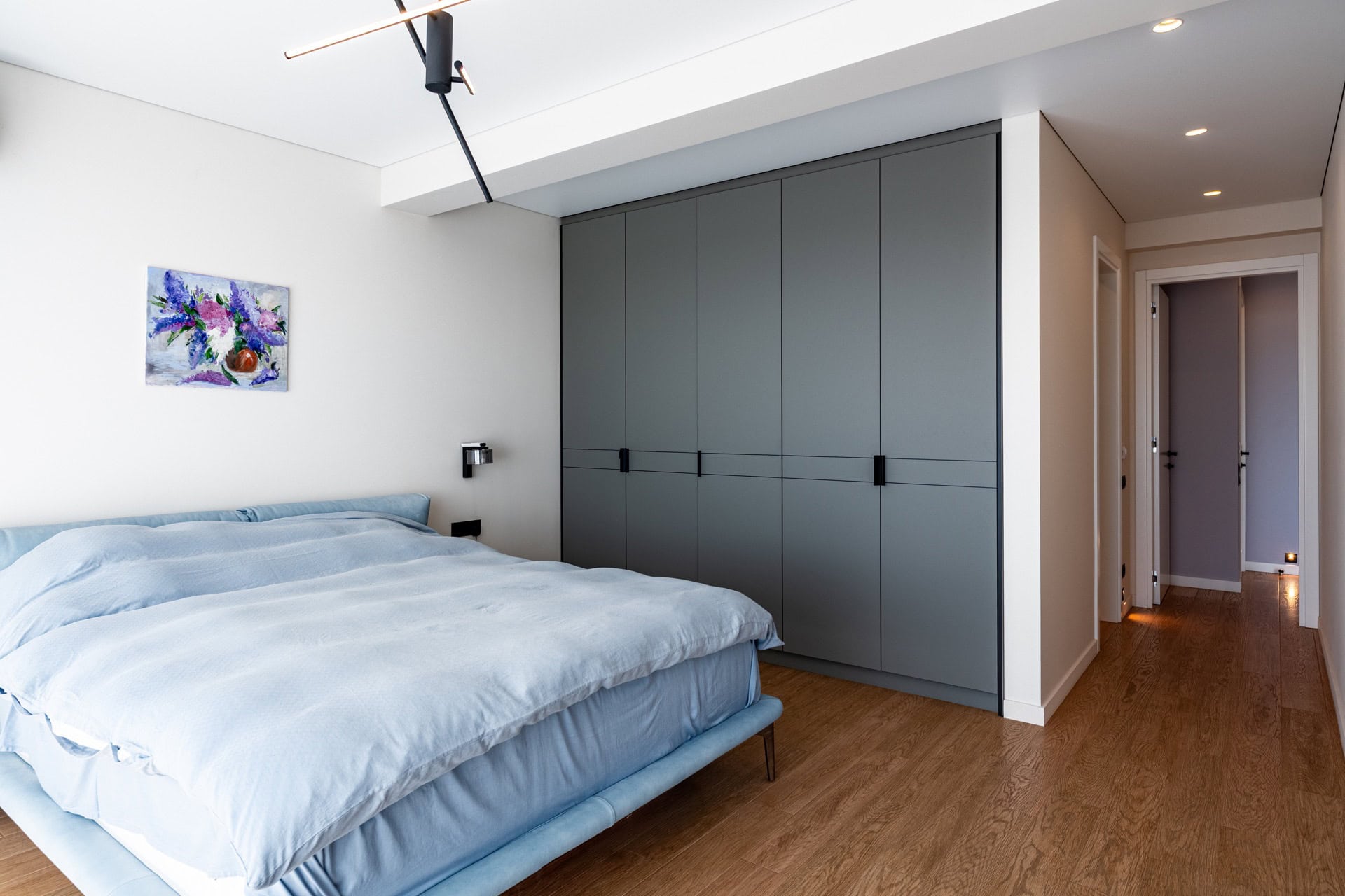 Modern bedroom with a double bed and built-in wardrobe in a villa in Kavac, Montenegro. Light-toned interior.