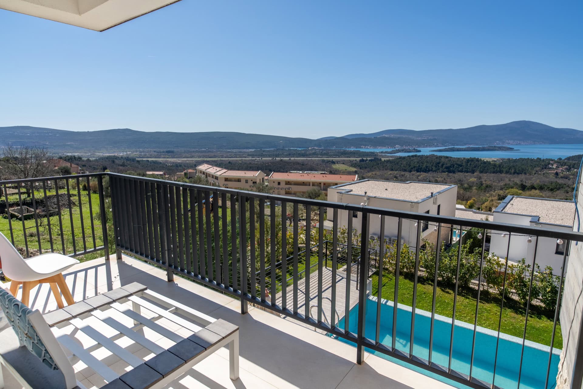 Villa balcony in Kavac, Montenegro: sea, mountain, and private pool views with modern garden furniture.