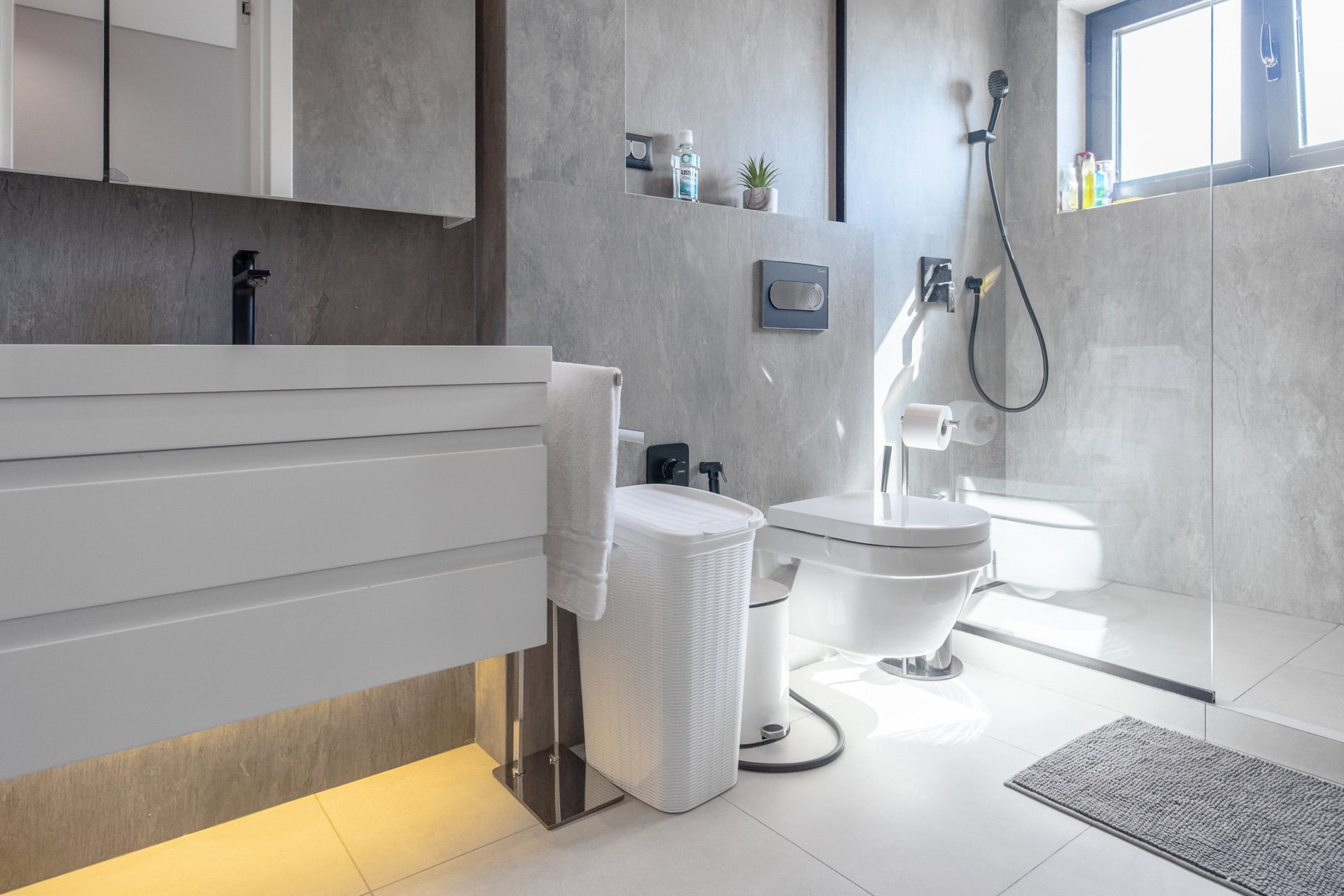 Modern bathroom with a shower cabin in a villa in Kavac, Montenegro: stylish concrete-look finishes and lighting.