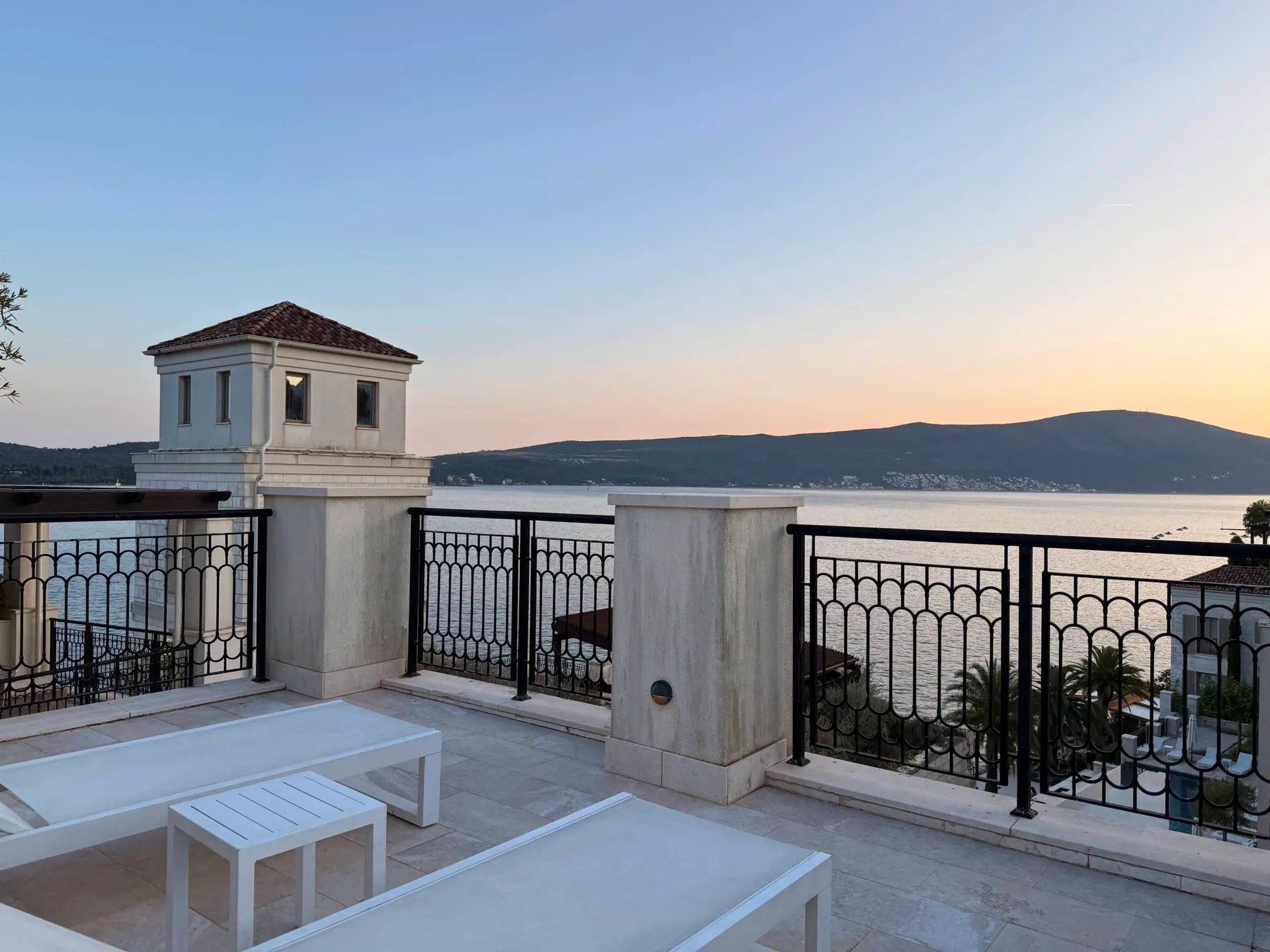 Terrasse mit Liegestühlen und Panoramablick auf das Meer und die Berge in einer exklusiven Wohnanlage, Tivat, Montenegro.