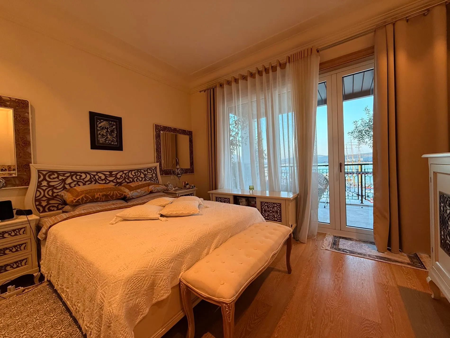 Gemütliches Schlafzimmer mit Doppelbett und Meerblick in einer Wohnung in Tivat, Montenegro. Helles Interieur mit Terrasse.