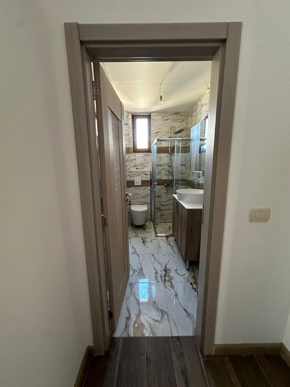 Modernes Badezimmer in einer Wohnung, Kumbor, Montenegro: Duschkabine, Waschtisch und Marmoroptik.