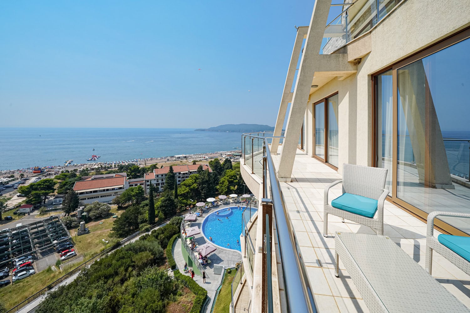 Prostran balkon sa nameštajem i panoramskim pogledom na more, plažu i bazen u Bečićima, Crna Gora.