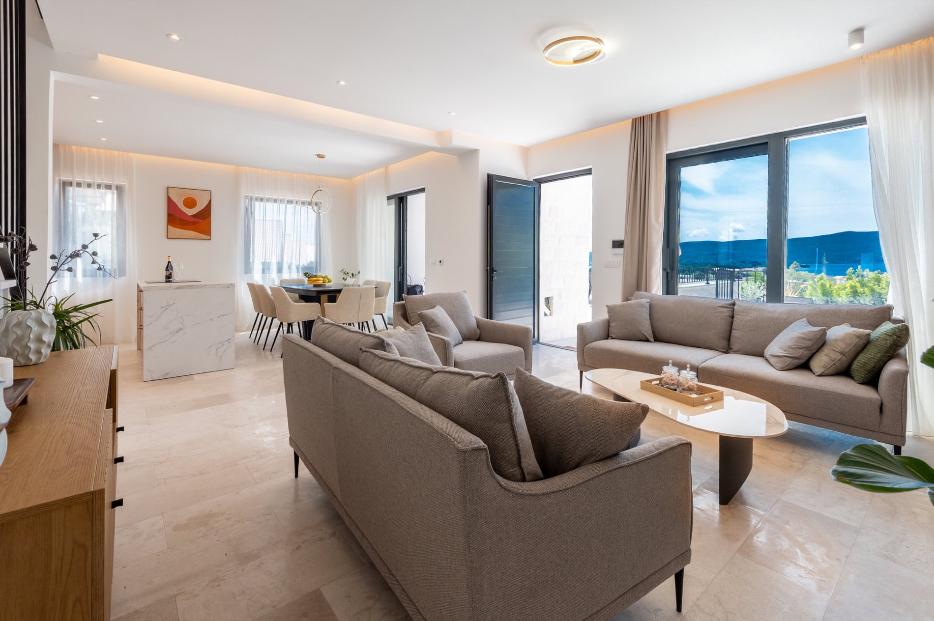 Modernes Wohnzimmer mit Panoramablick auf das Meer in einer exklusiven Villa in Tivat, Montenegro: stilvolle Möbel und Marmor.