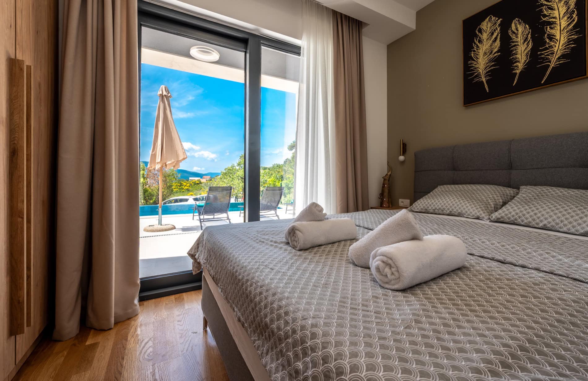 Schlafzimmer in einer Villa in Tivat, Montenegro: Doppelbett, Panoramafenster mit Zugang zum privaten Pool und zur Terrasse.