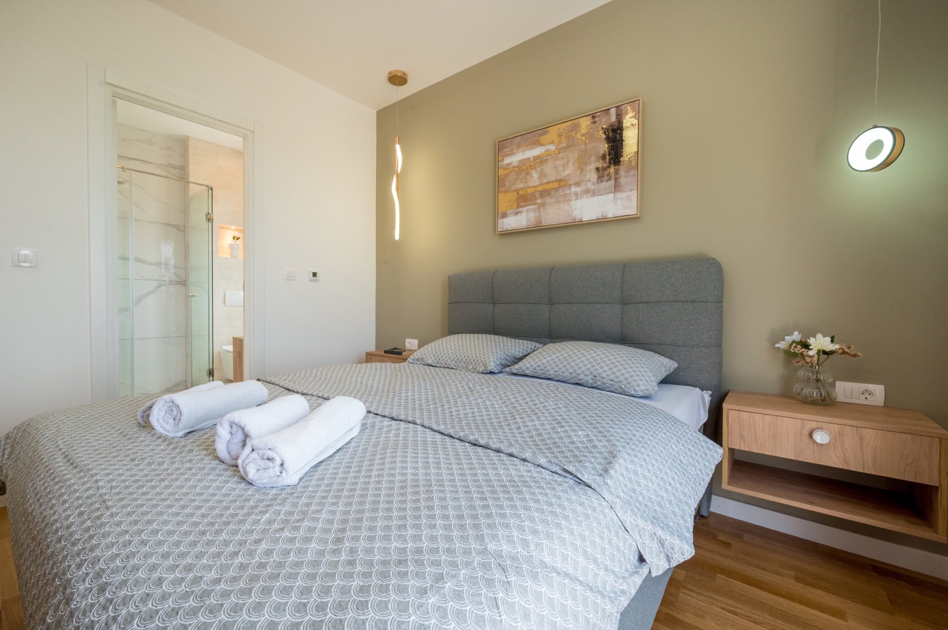 Modernes Schlafzimmer mit Doppelbett und Badezimmer in einer Villa in Tivat, Montenegro.