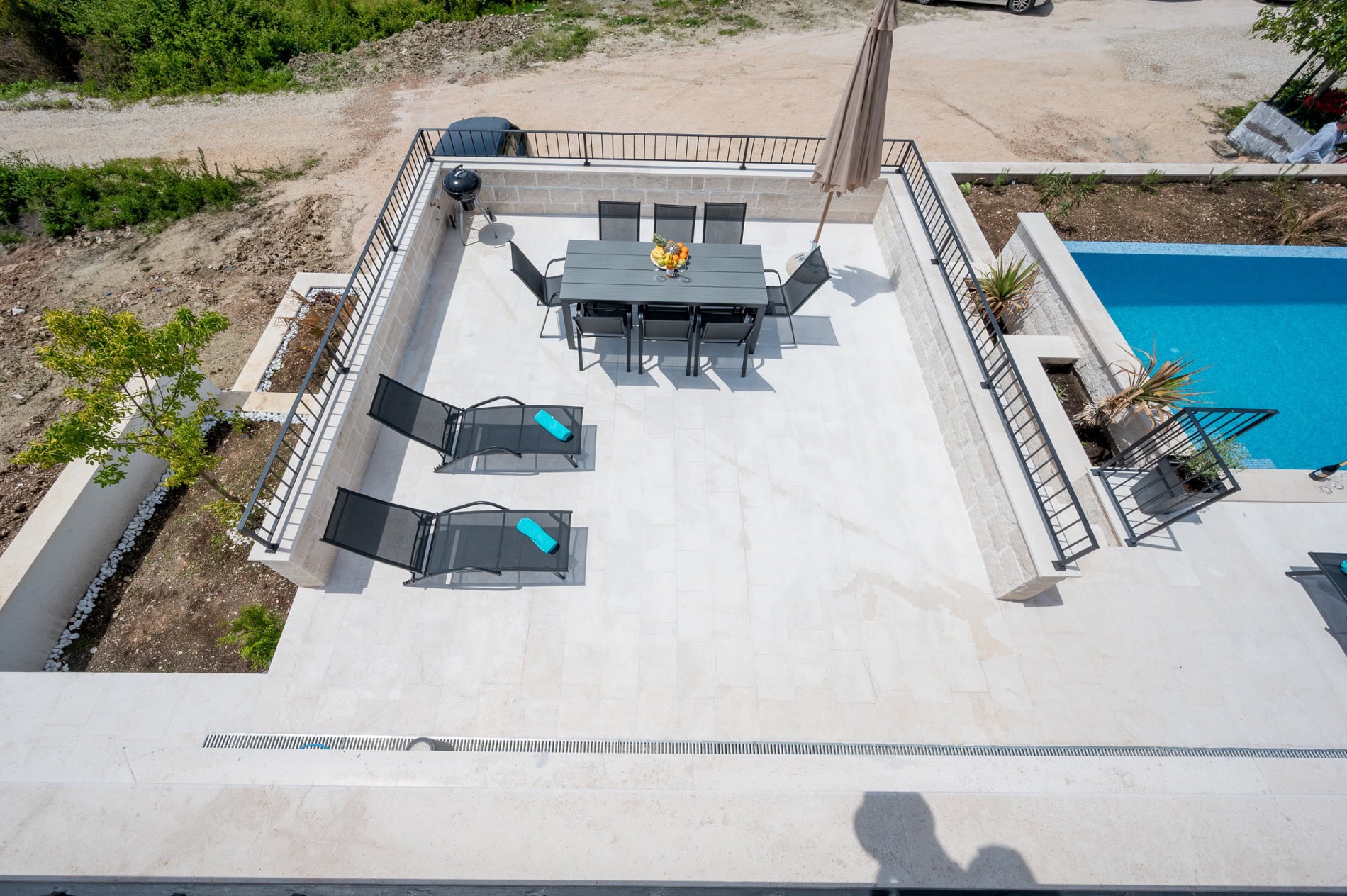 Terrasse der Villa in Tivat, Montenegro: Essbereich, Liegestühle und privater Pool mit Blick auf die Landschaft.