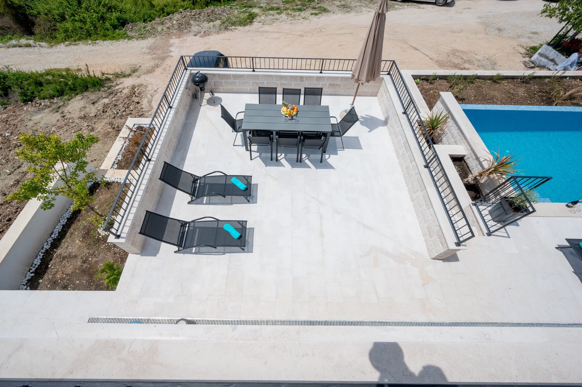 Terrasse der Villa in Tivat, Montenegro: Essbereich, Liegestühle und privater Pool mit moderner Steinverkleidung.