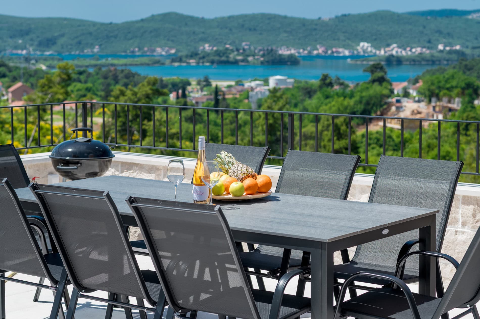 Terrasse der Villa in Tivat, Montenegro: Esstisch mit Früchten und Panoramablick auf das Meer und die Berge.