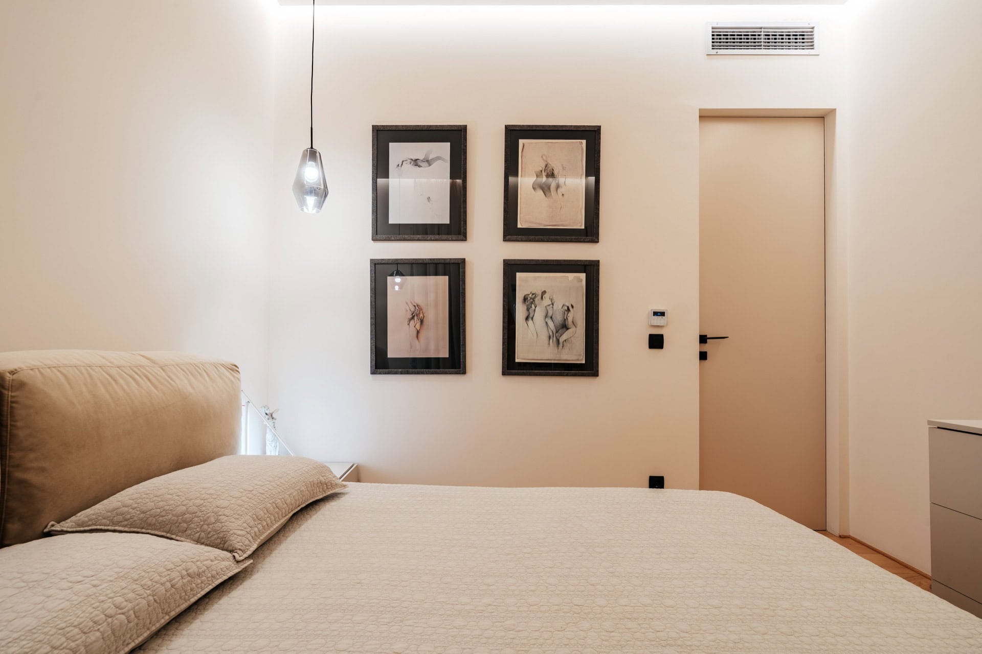 Modernes Schlafzimmer in einer Wohnung, Bečići, Montenegro: Doppelbett, stilvolle Wanddekoration und indirekte Beleuchtung.