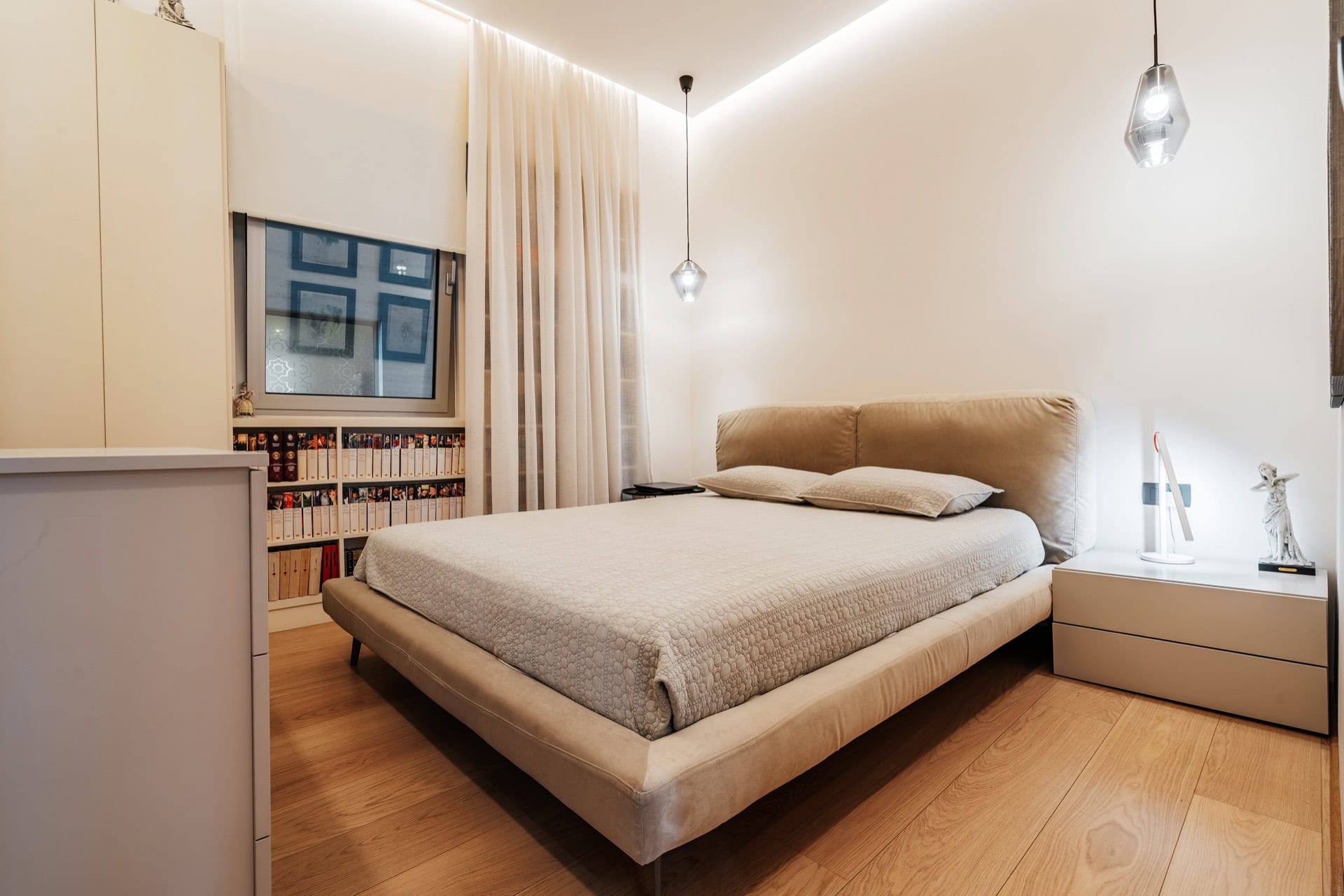 Modernes Schlafzimmer mit Doppelbett in einer Wohnung in Bečići, Montenegro: helles Interieur, Parkett und Beleuchtung.