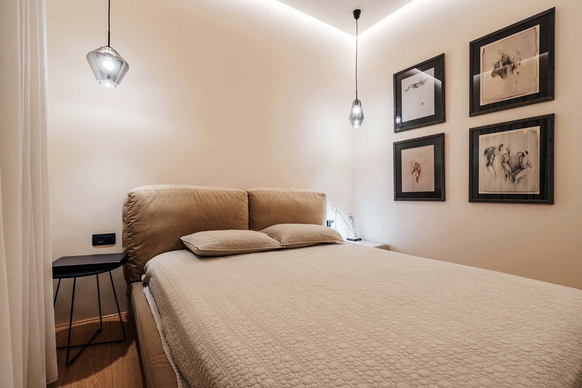 Modernes Schlafzimmer in einer Wohnung in Bečići, Montenegro: Doppelbett, Designerleuchten und Wanddekoration.