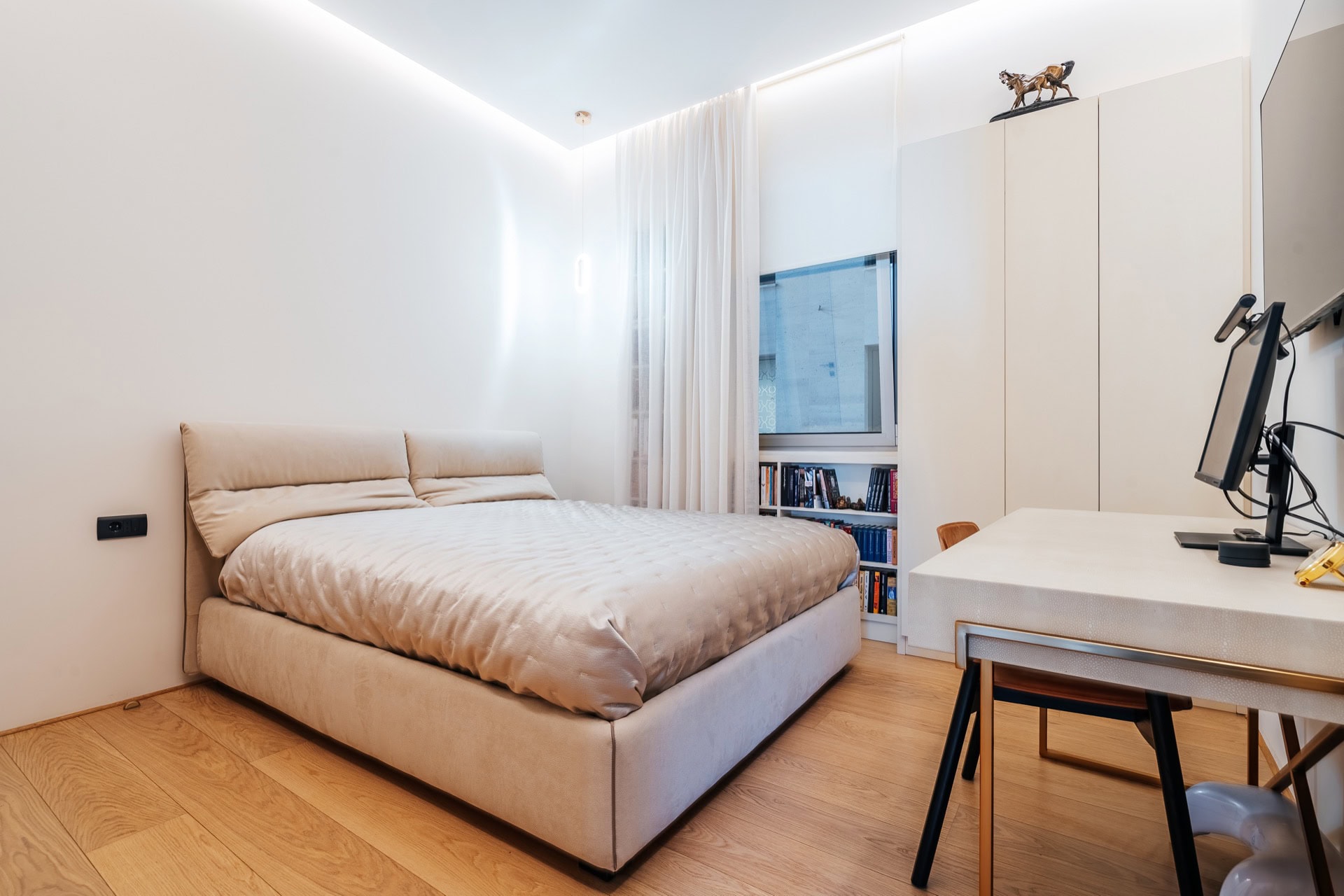 Modernes Schlafzimmer in einer Wohnung in Bečići, Montenegro: Doppelbett, Schreibtisch und Einbauschrank.