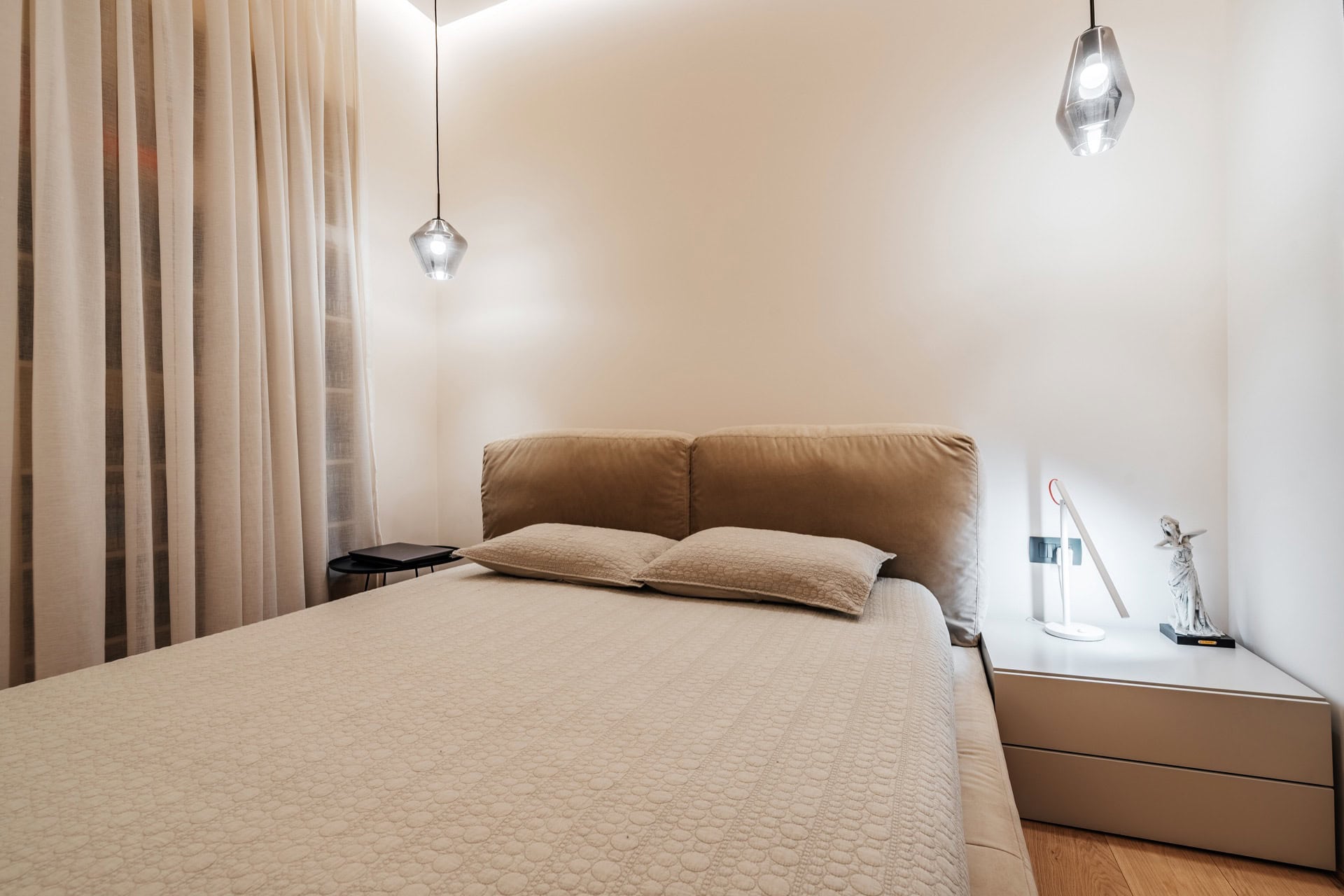 Modernes Schlafzimmer mit Doppelbett in einer Wohnung, Bečići, Montenegro: stilvolles Interieur, Designerleuchten.
