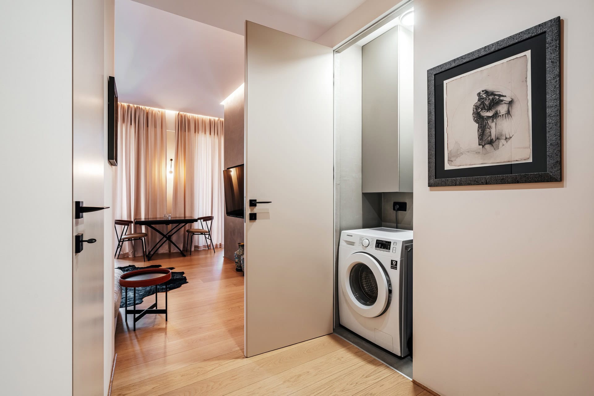 Versteckte Waschmaschine in einer Nische und modernes Wohnzimmerinterieur in einer Wohnung, Bečići, Montenegro.