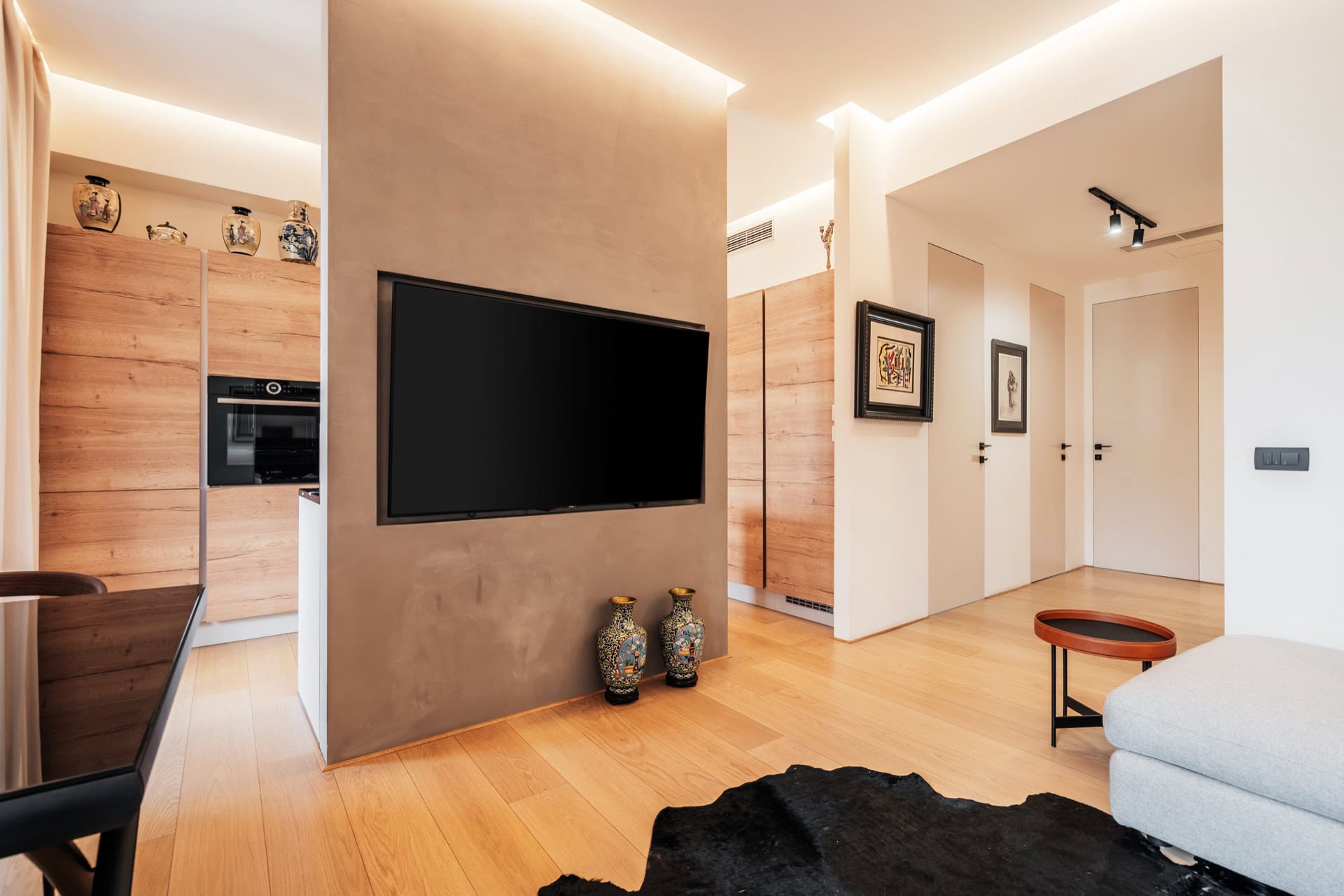 Modernes Wohnzimmer mit TV-Bereich und Küche in einer Wohnung in Bečići, Montenegro: stilvolles Interieur, Holzverkleidung.