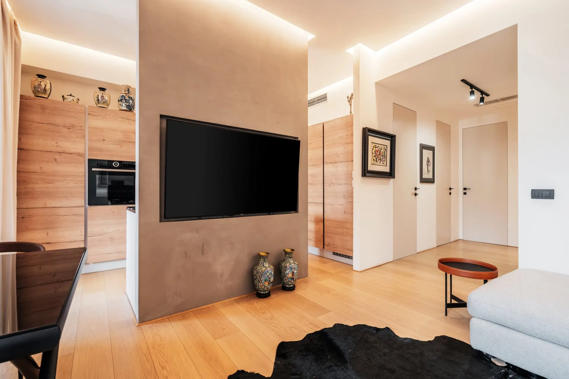 Modernes Wohnzimmer mit TV-Bereich und Küche in einer Wohnung in Bečići, Montenegro: stilvolles Interieur, Holzverkleidung.