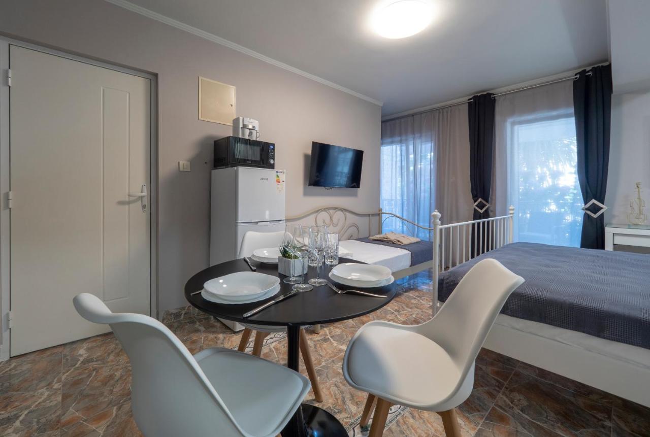 Bedroom interior in a hotel in Pržno, Montenegro: double bed, dining table, kitchenette, and access to the balcony.