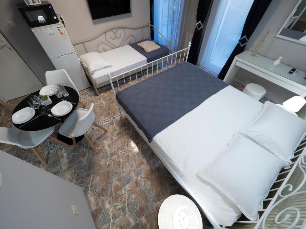Bedroom interior in a hotel in Pržno, Montenegro: a double bed, dining area, and modern furniture in the room.