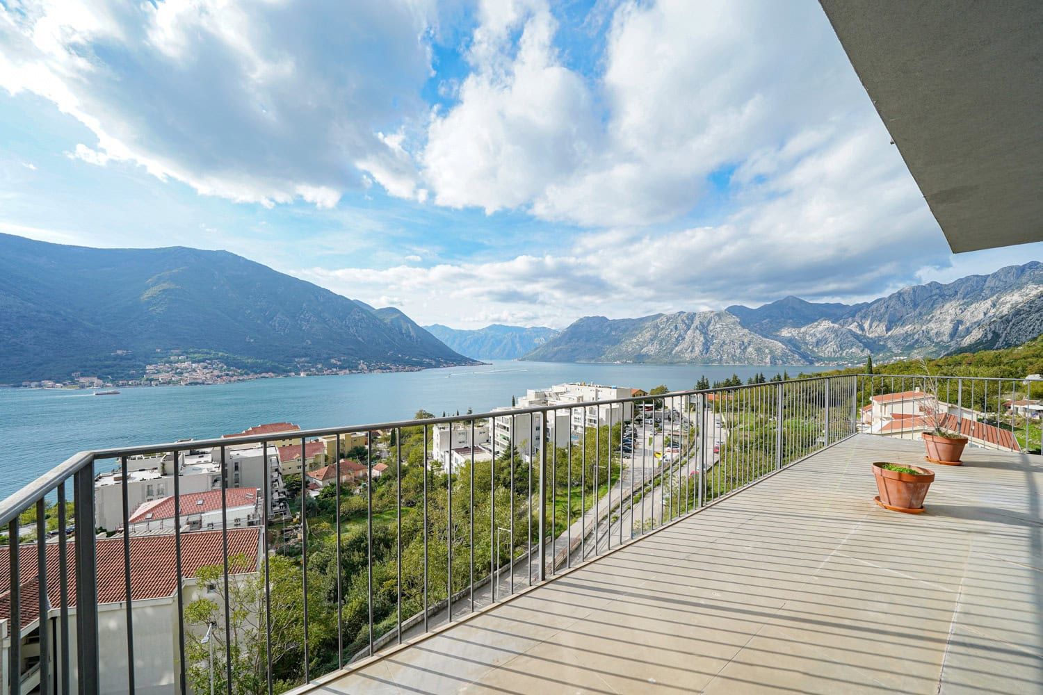 Przestronny balkon z panoramicznym widokiem na Zatokę Kotorską i góry w Dobrocie, Czarnogóra.