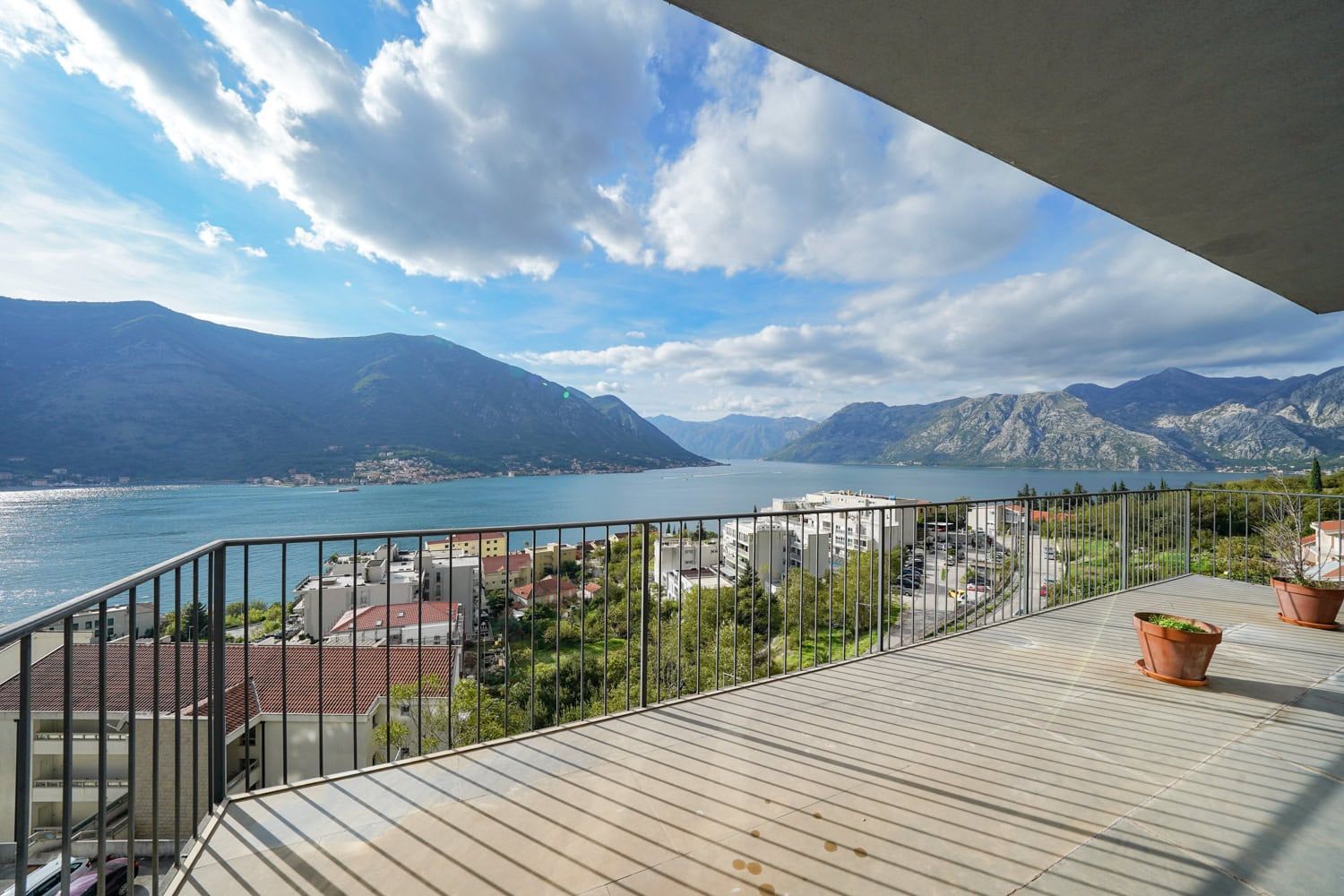 Przestronny balkon mieszkania w Dobrocie, Czarnogóra, z panoramicznym widokiem na Zatokę Kotorską i górskie krajobrazy.