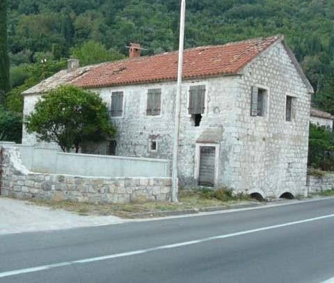 An old stone house for renovation in Kamenari, Montenegro: natural stone facade and a tiled roof.