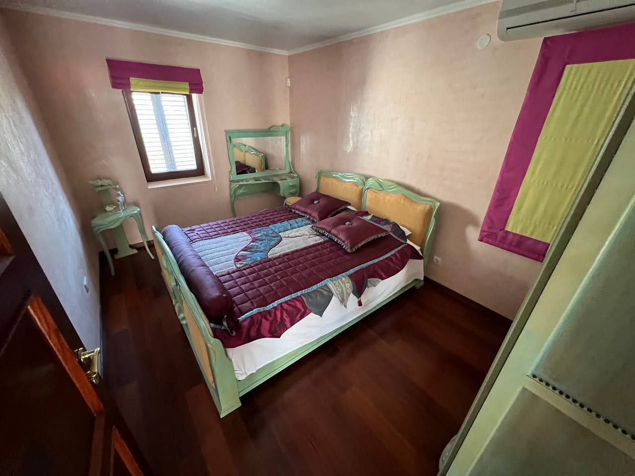 Bedroom with a double bed and vanity table in a villa in Kamenari, Montenegro. Parquet floor, air conditioning.