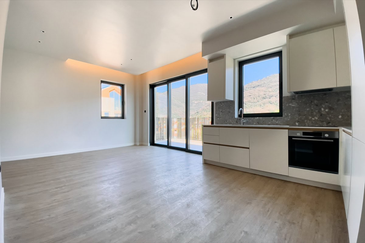 Moderne Wohnküche in einer Wohnung in Tivat, Montenegro: helles Interieur, Einbaugeräte und Bergblick.