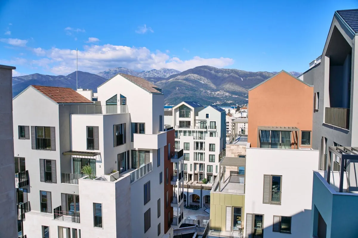 Blick auf moderne Wohnhäuser in Tivat, Montenegro, mit Panoramablick auf die Berge und die städtische Architektur.
