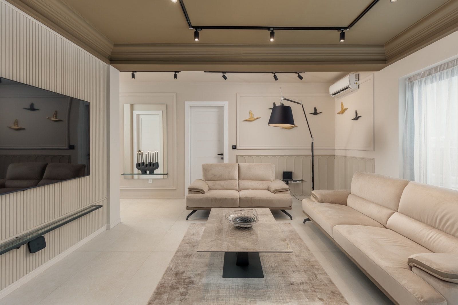 Nowoczesny salon z beżowymi sofami i designerskim oświetleniem w apartamencie, miasto Dobrota, Czarnogóra.