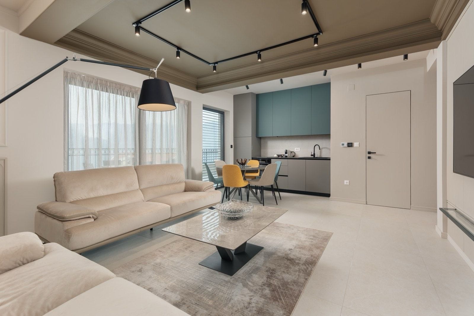 Nowoczesny salon z kuchnią w mieszkaniu w Dobrocie, Czarnogóra: beżowa sofa, jadalnia i stylowe wnętrze.