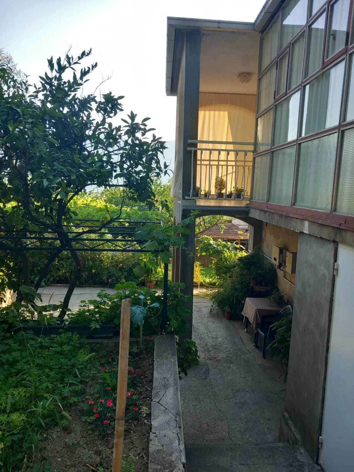 Zweistöckiges Haus in Igalo, Montenegro: Terrasse, Panoramaverglasung und grüner Garten mit Weinberg im Hof.