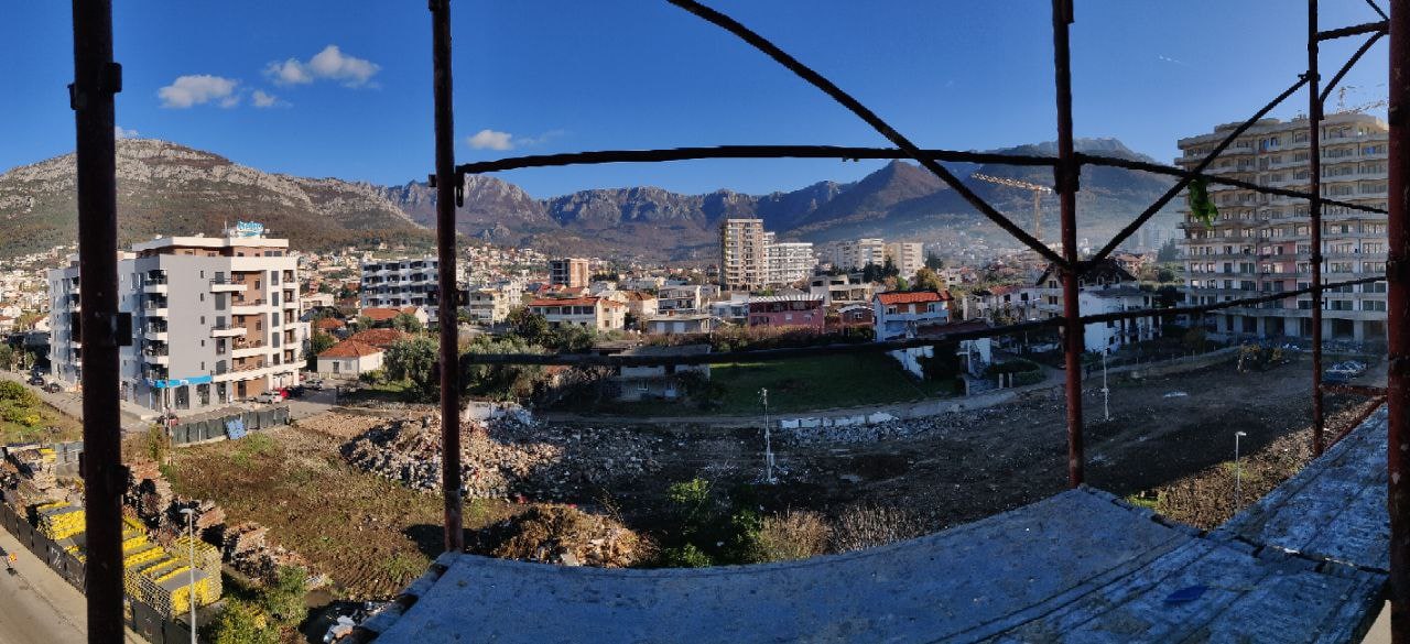 Karadağ, Bar şehrinde inşaat halindeki bir binanın balkonundan görünüm: şehir panoraması, konut kompleksleri ve dağ manzarası.