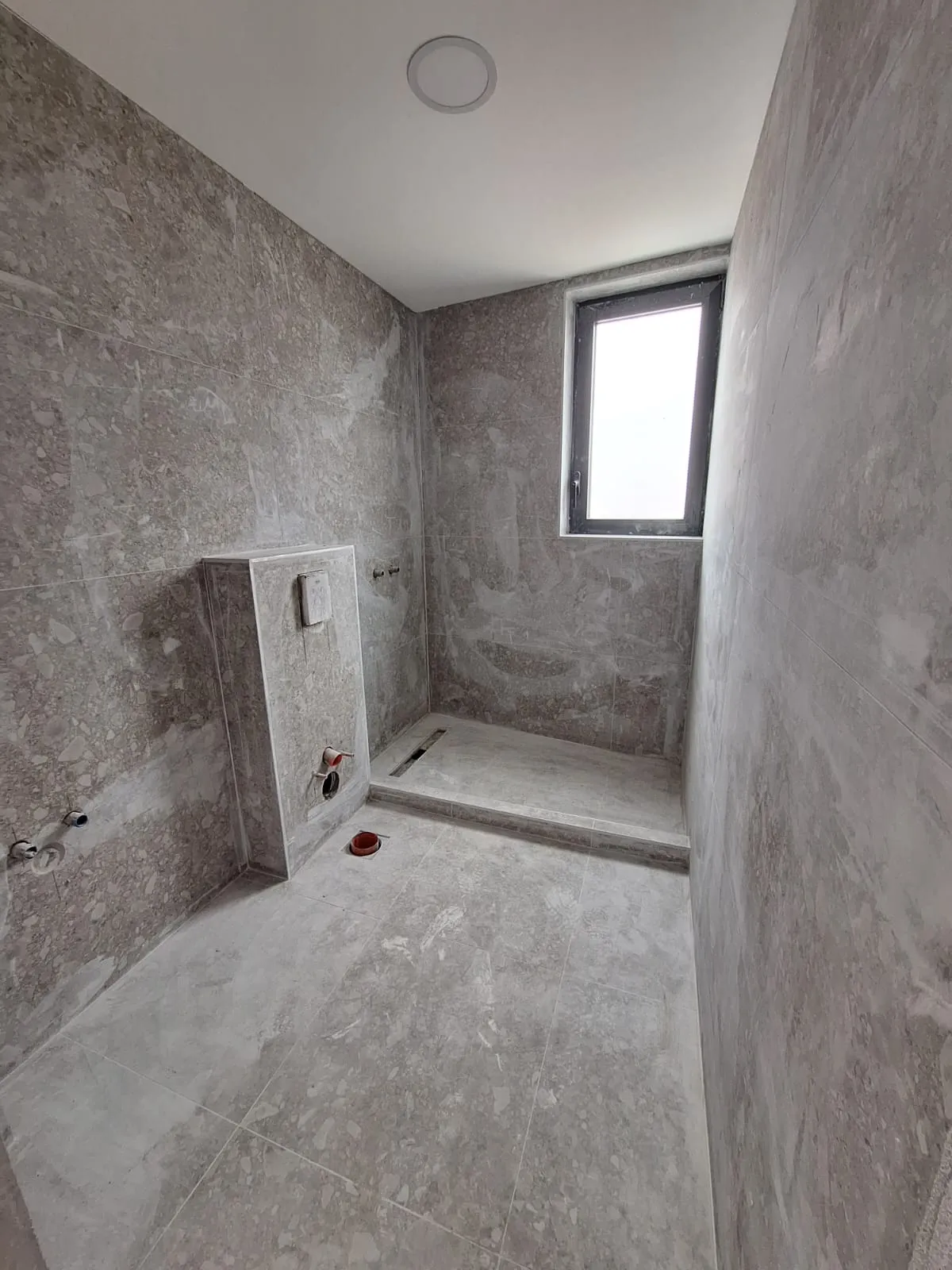 Bathroom renovation with grey tiles and window