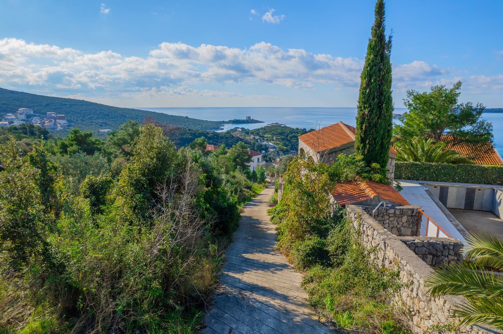Zemljište u Žanjicama, Crna Gora: panoramski pogled na more, brda i mediteransku prirodu sa stazom do kuće.