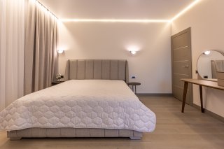Modernes Schlafzimmer mit Doppelbett und Schminktisch in einer Villa in Bečići, Montenegro. Stilvolles Interieur.