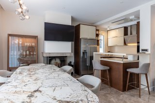 Moderne Wohnküche mit Marmortisch, Kamin und Bartheke in einer Villa in Bečići, Montenegro.