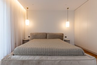 Modernes Schlafzimmer mit Doppelbett und Einbauschrank in einer Villa in Bečići, Montenegro. Design-Interieur.