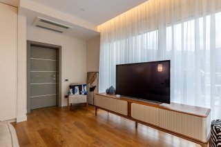 Modernes Wohnzimmer mit TV-Bereich in einer Villa, Bečići, Montenegro: Parkettboden, Designermöbel und Panoramafenster.