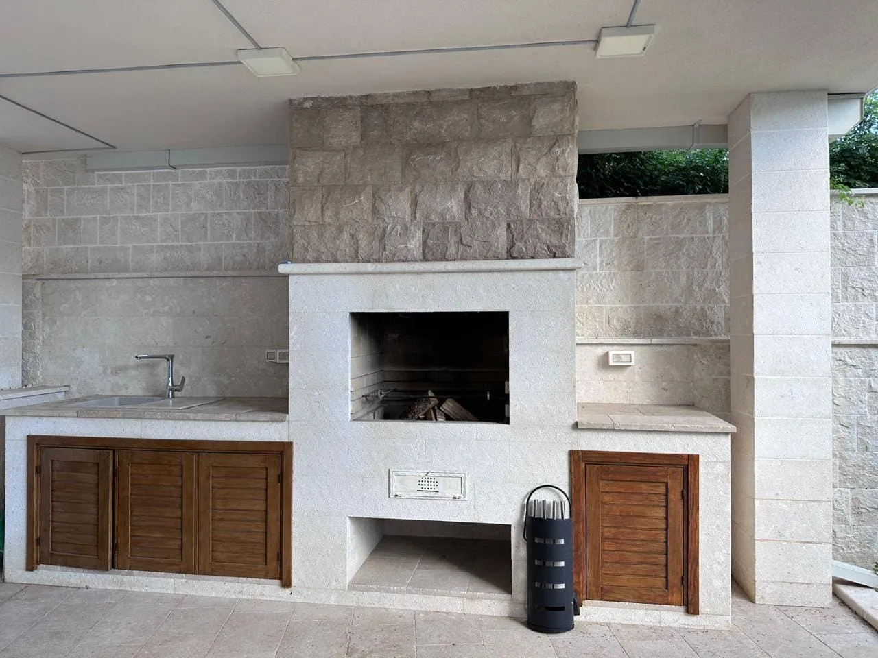 Sommerküche mit Steingrill und Spüle auf der Terrasse einer Villa in Bečići, Montenegro. Ausführung aus Naturstein.