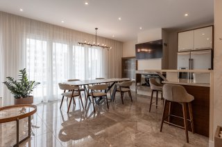 Modernes Wohnzimmer mit Essbereich und Küche in einer Villa in Bečići, Montenegro: Marmorboden, stilvolle Möbel.