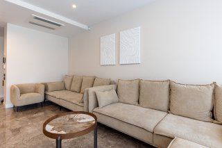 Helles Wohnzimmer mit beigen Sofas und Marmorboden in einer Villa in Bečići, Montenegro. Modernes Interieur.