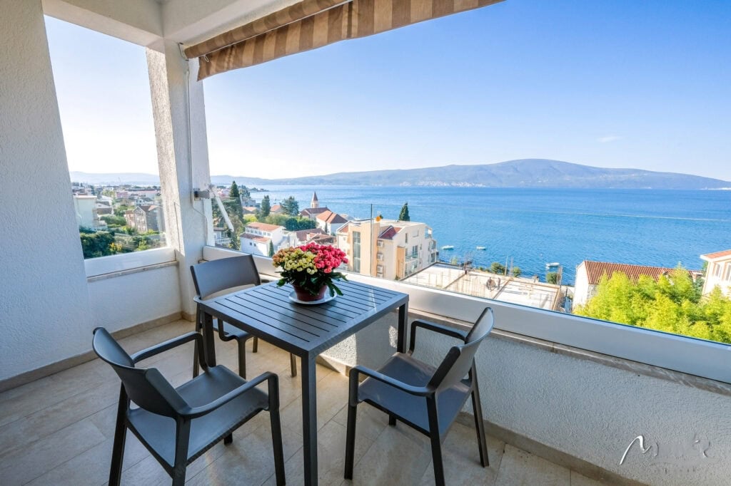Terasa sa nameštajem i panoramskim pogledom na more i planine u stanu, grad Tivat, Crna Gora.