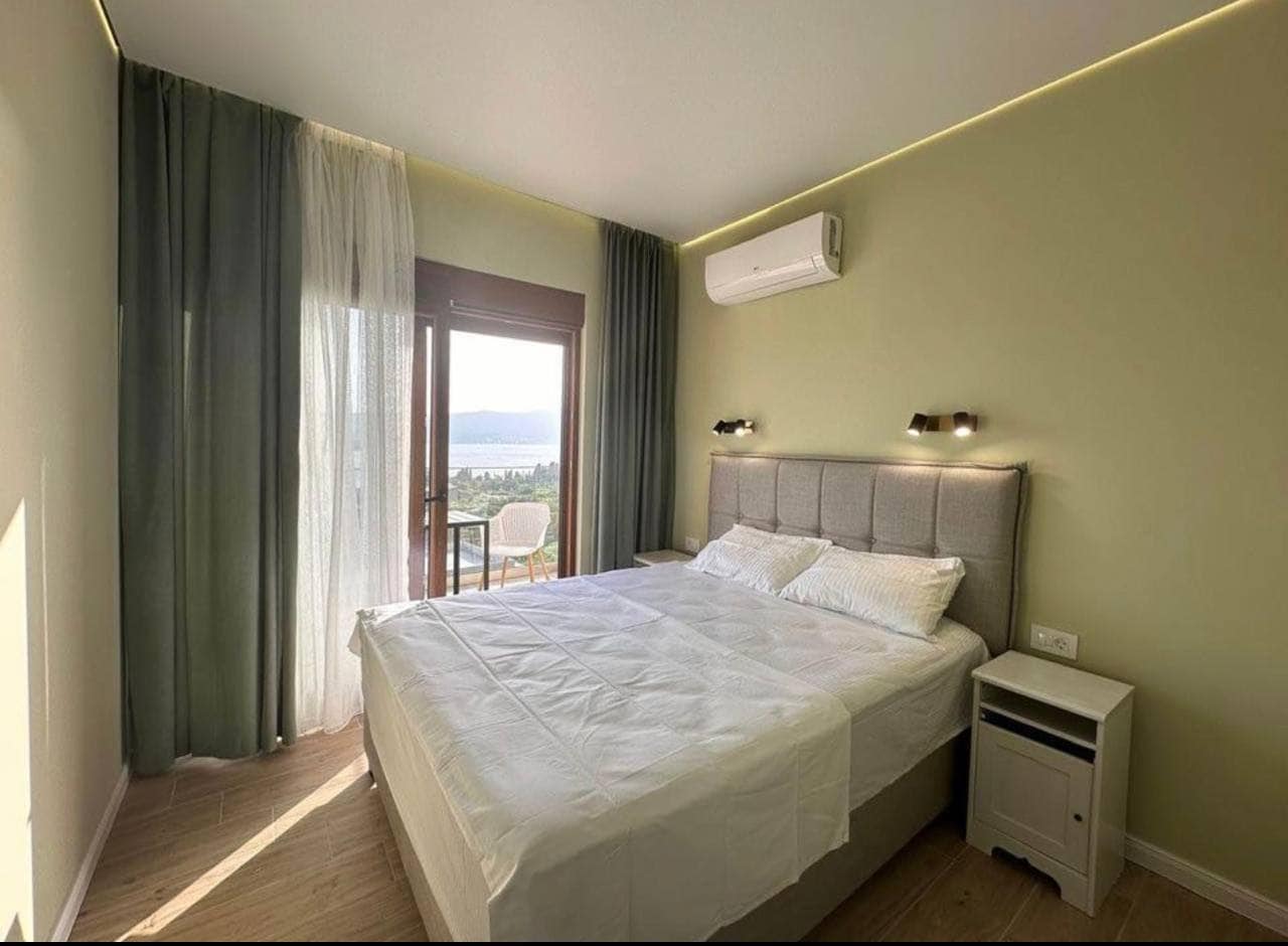 Savremena spavaća soba u stanu u Tivtu, Crna Gora: bračni krevet, panoramski pogled na more i balkon.